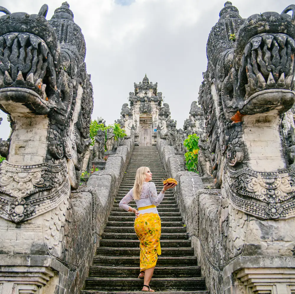 Female tourist wearing Balinese traditional attire on the stairs of Lempuyang Temple during Bali Instagram Tour
