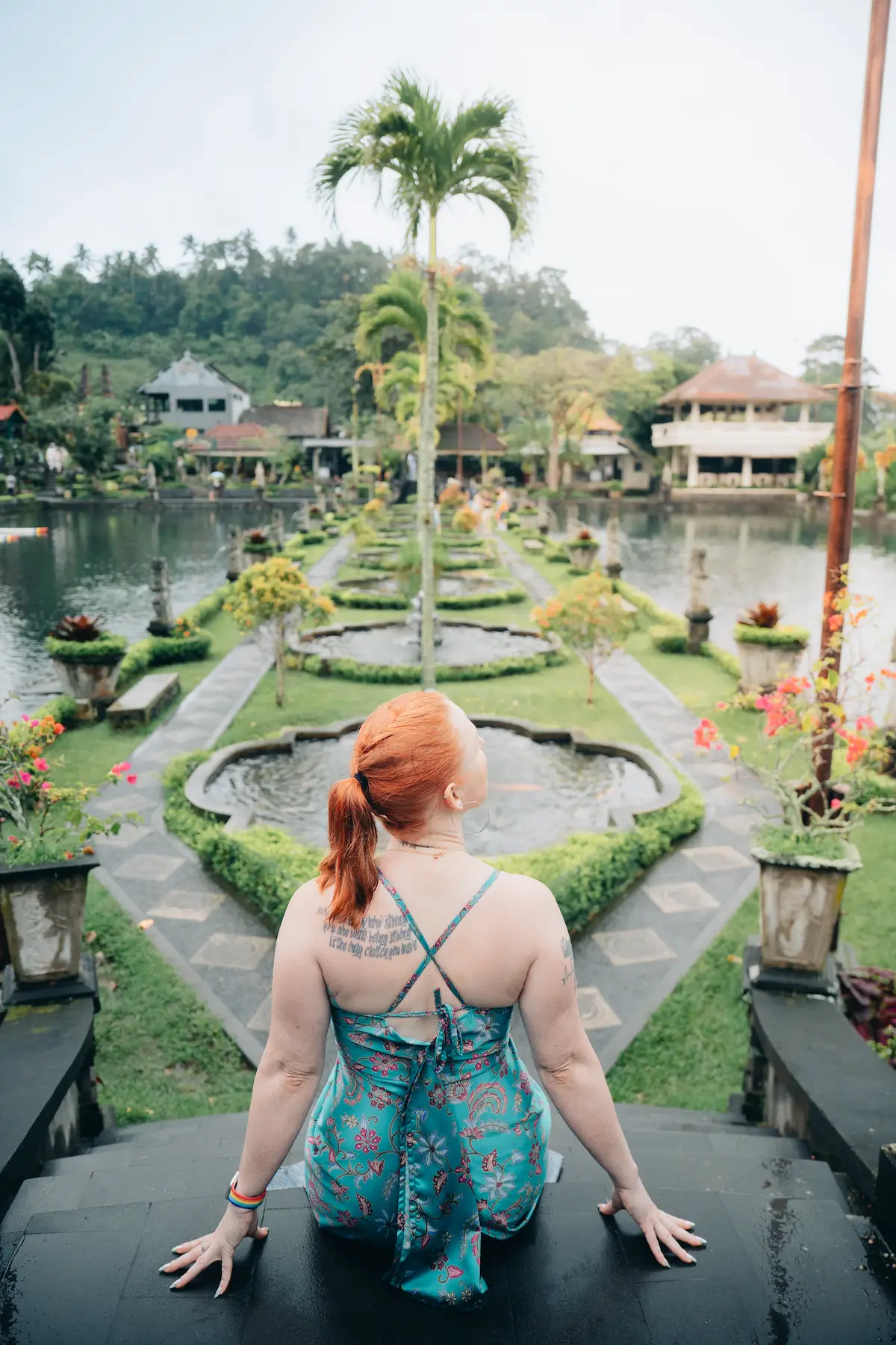 Female tourist admiring the garden view at Tirta Gangga Water Palace – a top Bali Instagram place.