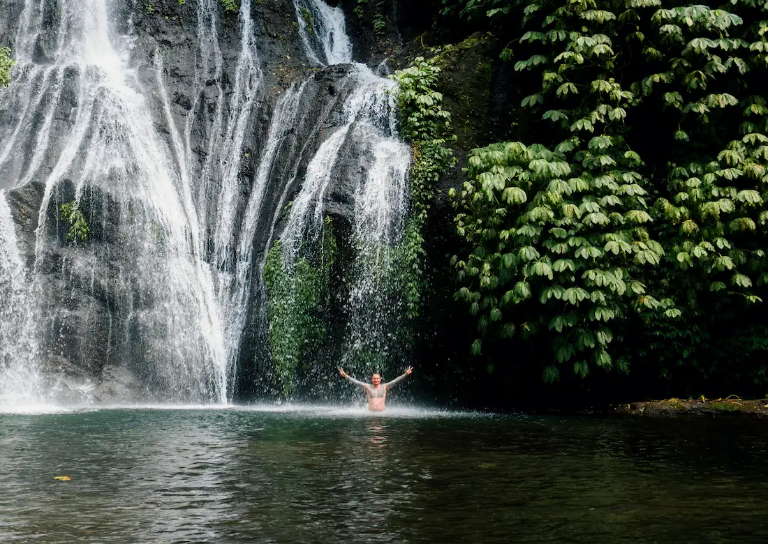 Man bathing at Banyumala Waterfall on Bali Waterfall Tour