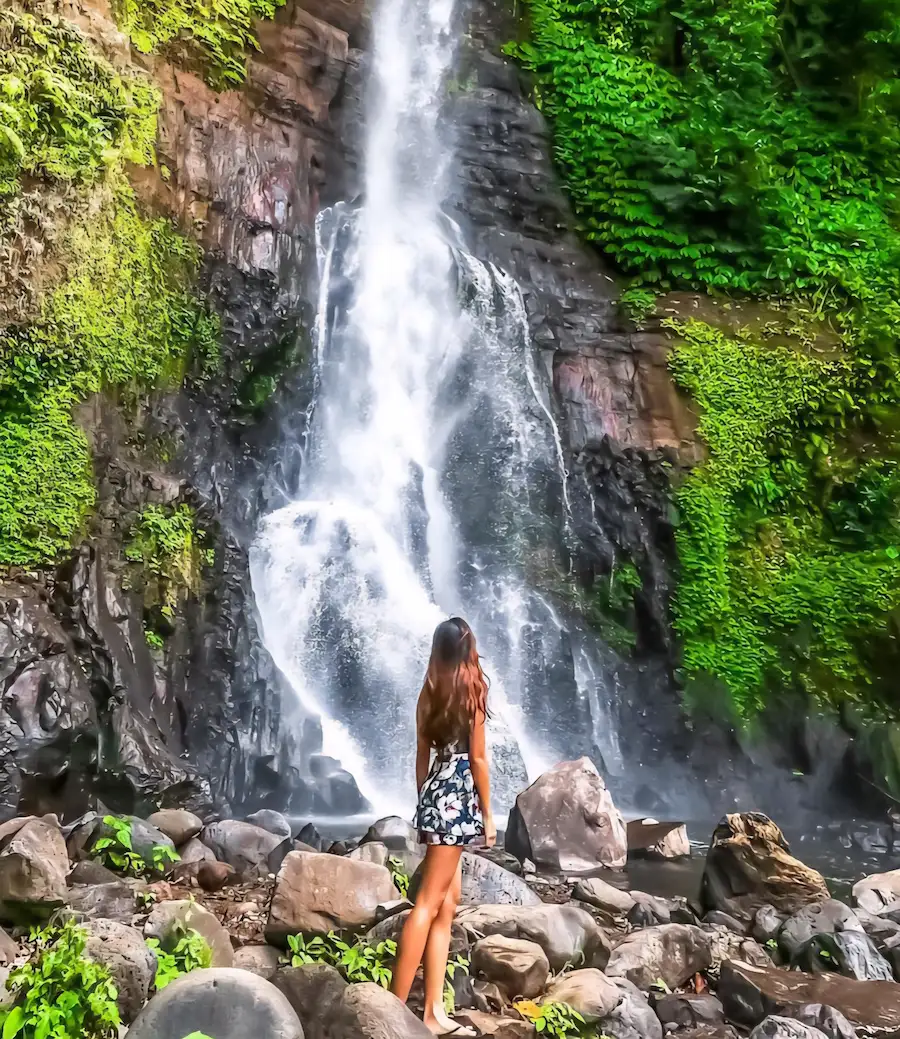 Female traveler admiring Gitgit, a famous North Bali waterfall