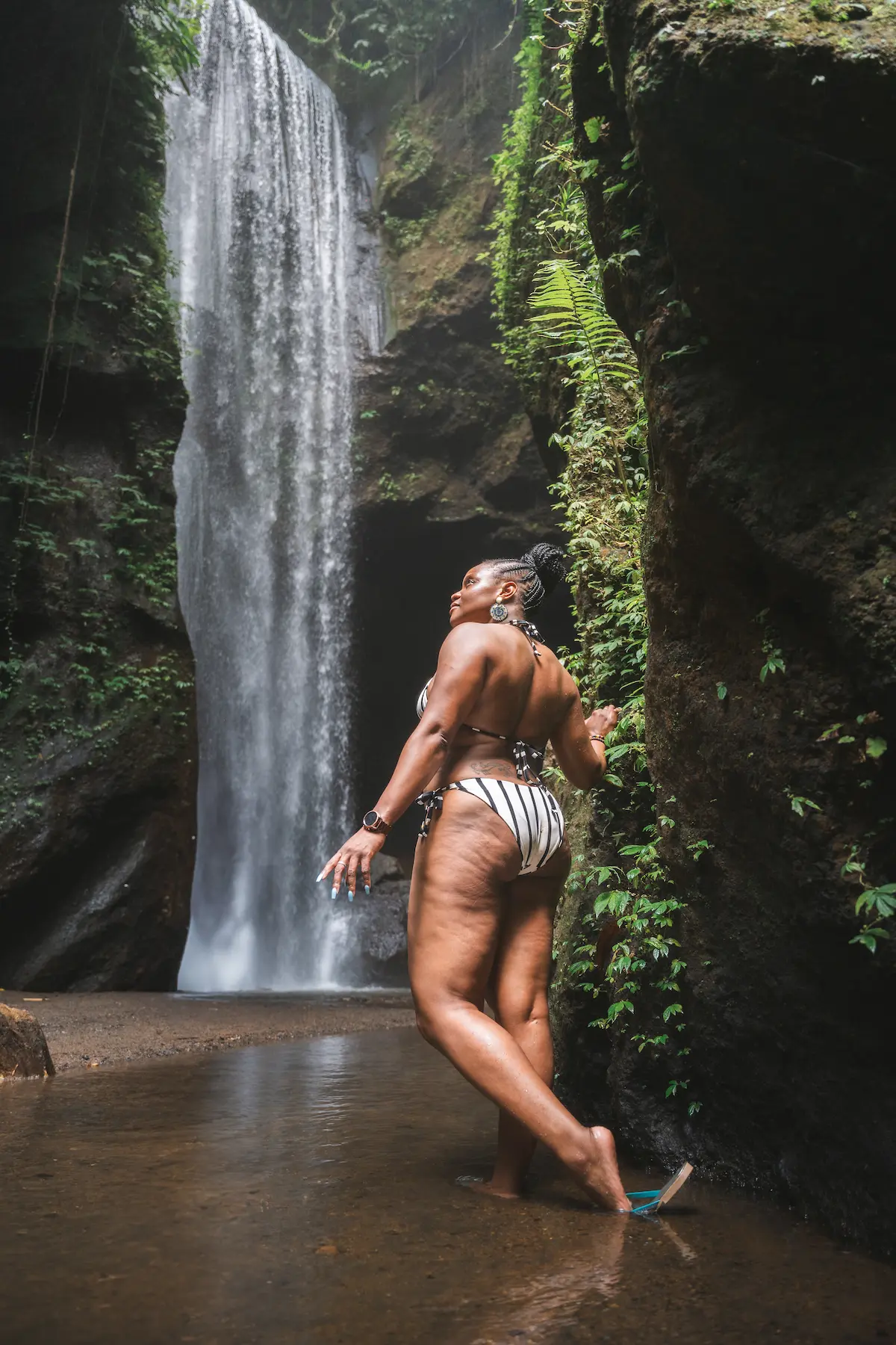 Female traveler at Goa Raja Waterfall during Bali Instagram Tour experience.