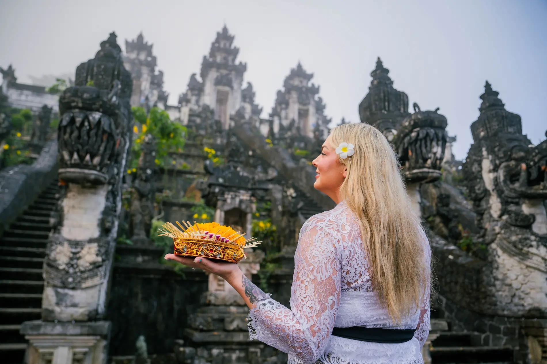 Female tourist in Balinese traditional attire facing Lempuyang Temple, cultural highlight of a Bali photography tour