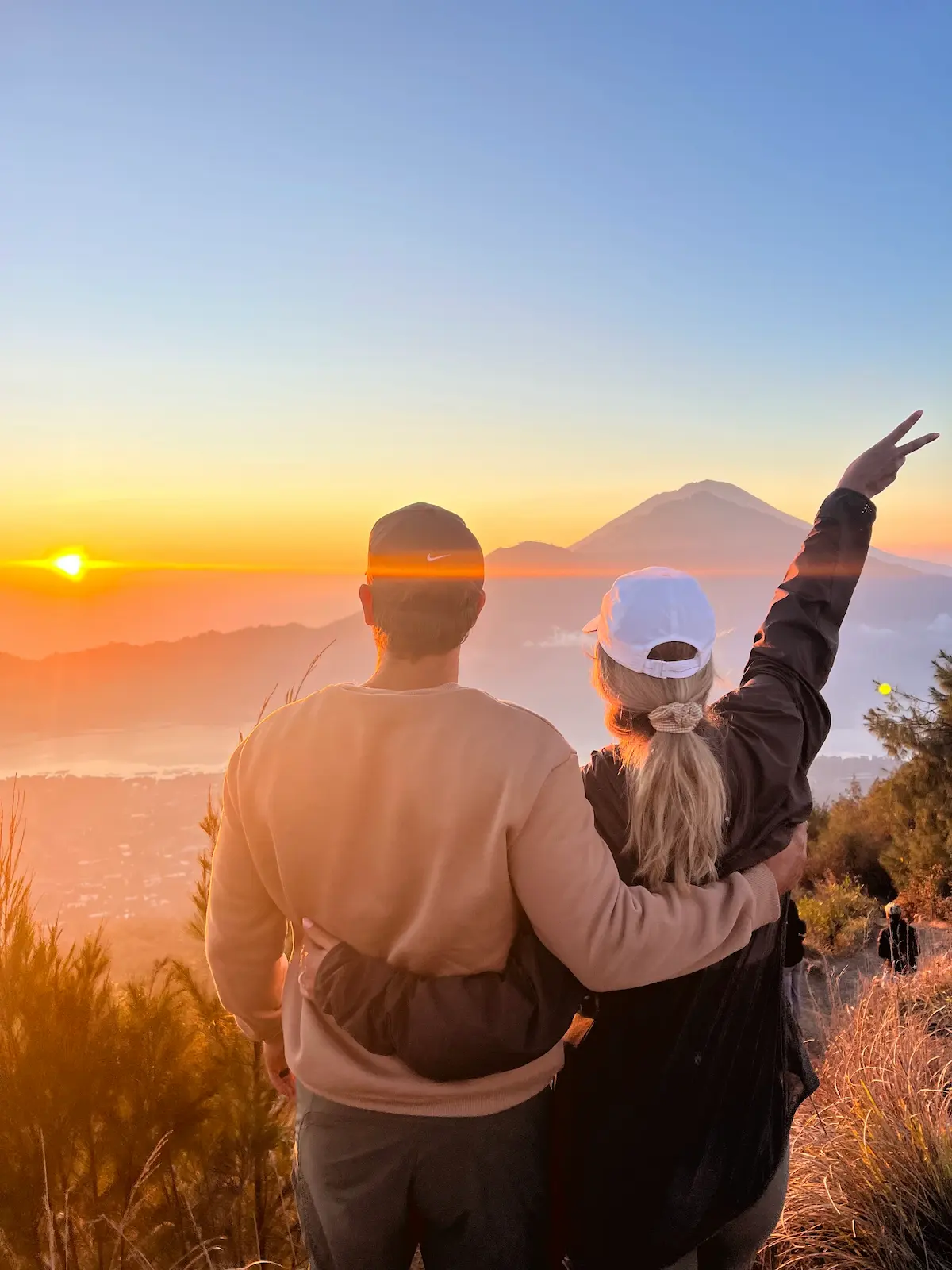 Romantic couple witnessing sunrise from Mount Batur during Batur Sunrise Trekking in Bali