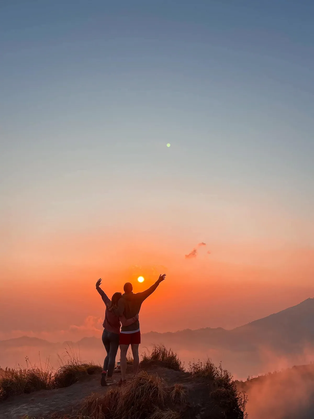 Couple enjoying the sunrise during Batur Sunrise Trekking on Mount Batur, Bali