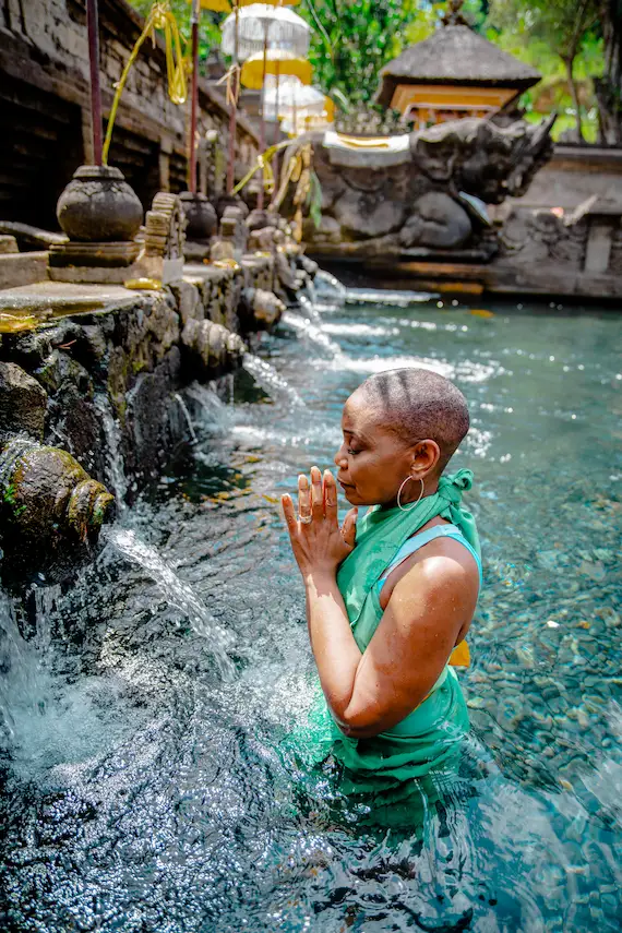 Woman doing purification ritual at Tirta Empul Temple during Ubud day trip