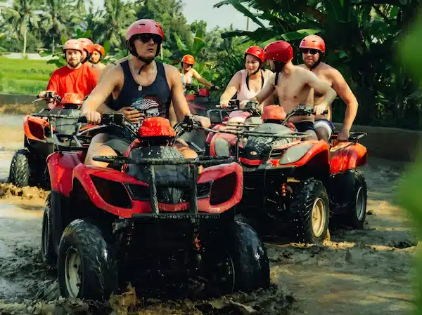 Couple riding ATV through jungle trail in Ubud, Bali.