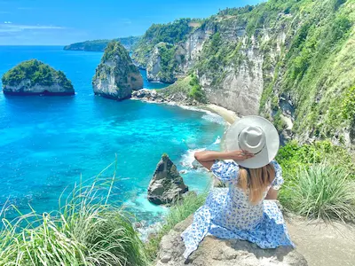 Woman on Diamond Cliff Nusa Penida enjoying breathtaking coastal views